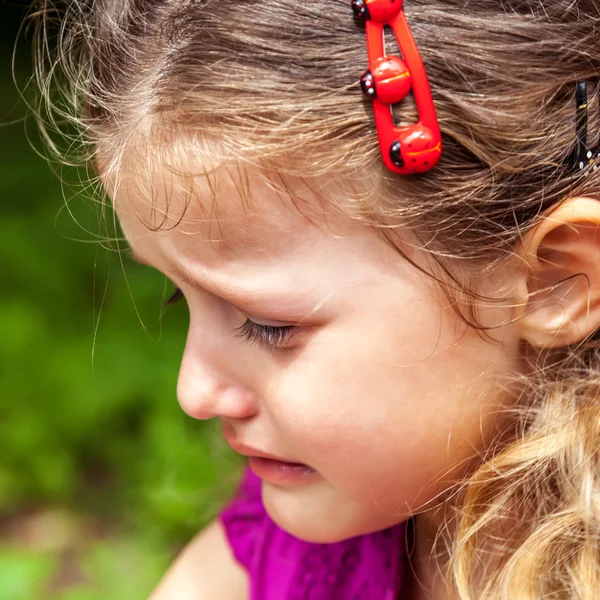 Petite fille mignonne pleurant sur le fond d'herbe verte . — Photo