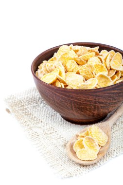 Beyaz arka plan üzerinde ahşap bir kase mısır gevreği.