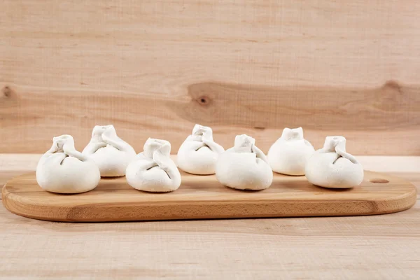 Manti dumplings on a wooden board. — Stock Photo, Image