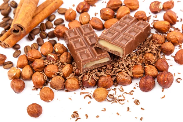 Chocolate, nuts and cinnamon sticks. — Stock Photo, Image