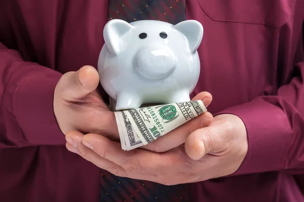 Piggy bank in the hands of a man in a shirt and tie — Stock Photo, Image