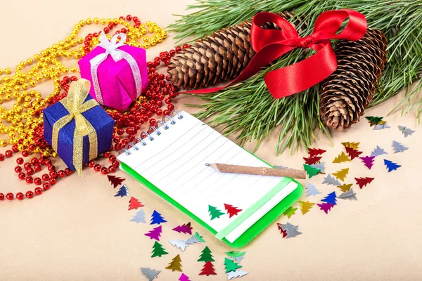 Christmas gifts, note pad, pencil and spruce branches — Stock Photo, Image