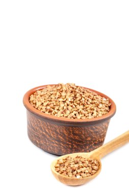 Buğday bir seramik kase ve bir tahta kaşık.