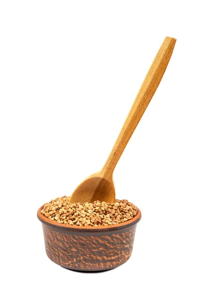 Buckwheat in a ceramic bowl and a wooden spoon. — Stock Photo, Image