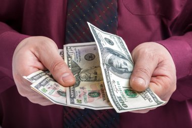 Bir iş adamı elinde dolar faturaları.