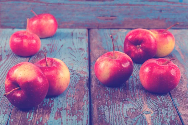 Frische Äpfel auf bemalten blauen Holzbrettern — Stockfoto