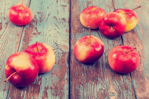 Frische Äpfel auf bemalten blauen Holzbrettern — Stockfoto