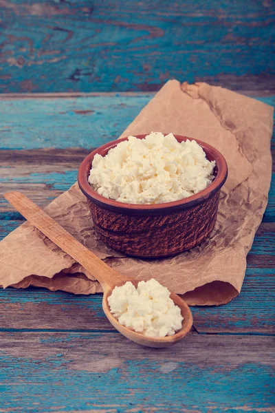 Fresh cottage cheese in a ceramic dish and spoon — Stock Photo, Image