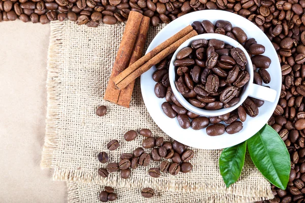 Coffee beans in a white cup on canvas — Stock Photo, Image