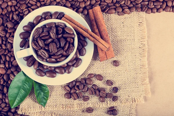 Grãos de café em uma xícara branca na tela — Fotografia de Stock