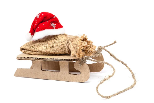 Sleigh with a sack and a Santa Claus hat. — Stock Photo, Image