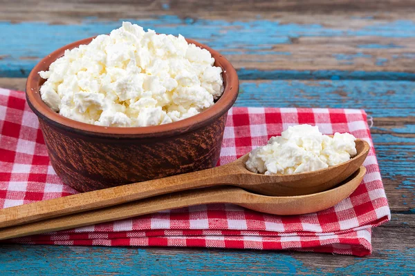 Fresh cottage cheese in a ceramic dish and spoon — Stock Photo, Image