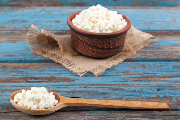 Fresh cottage cheese in a ceramic dish and spoon — Stock Photo, Image