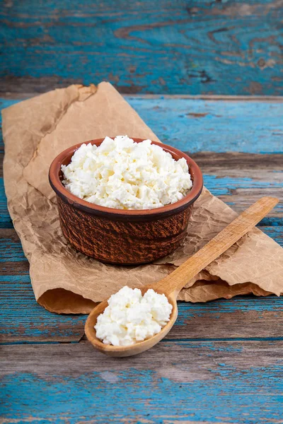 Fresh cottage cheese in a ceramic dish and spoon — Stock Photo, Image