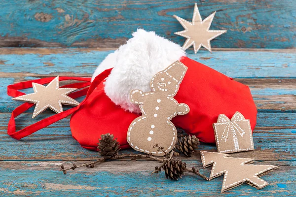 Red mittens with fur and a branch of pine tree with cones — Stock Photo, Image