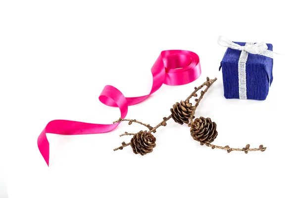 Weihnachtsgeschenk, rosa Schleife und ein Tannenzweig mit Zapfen — Stockfoto