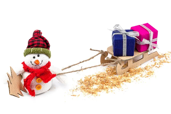 Снеговик с санями, елкой и подарками — стоковое фото