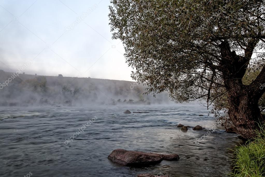 Mountain river with rapids in the morning mist