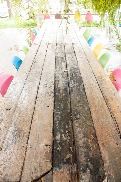 Houten eettafels met vele kleurrijke stoel — Stockfoto