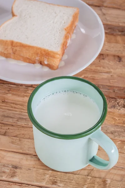 Vintage cup färsk mjölk bröd med smör — Stockfoto