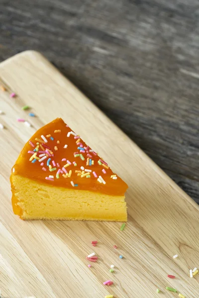 Orange cake slice on wood plate — Stock Photo, Image