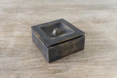 ahşap masa üzerinde bronz kül tablası