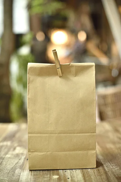 Classic paper bag on wood table in light — Stock Photo, Image