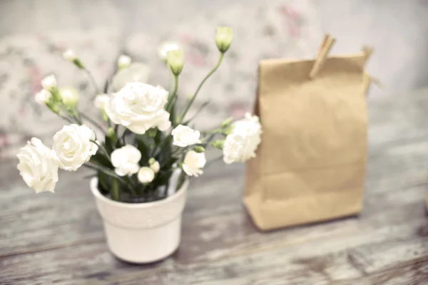 Klassische weiße Rose und Papiertüte auf Holztisch — Stockfoto