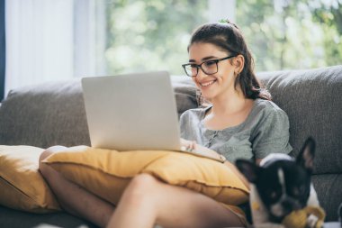 Evden video görüşmesi için teknoloji bilgisayarı kullanan bir kadın, laptop ve internetle iş iletişimi, internet üzerinden çalışma ve görüşme, ofisten uzak konferans