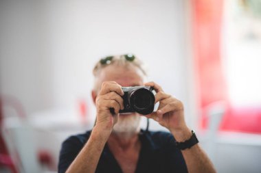 Elinde kamera olan yaşlı bir adamın portresi. 