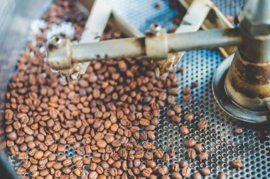 Kahve çekirdeği kızartma makinesi ekipmanları içecek işi için çalışıyor, kafe için kızartma hazırlama işlemi, aromatik kahverengi kahve kavrulmuş, aroma espresso sıcak içeceği..