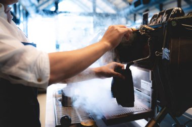 Kafedeki espresso kahve makinesi, kahve yapan profesyonel barmen, bir dükkan veya restoranda barın üzerinde bir fincan kafein, modern kahve dükkanı, kahverengi kapuçino içecek üreticisi.