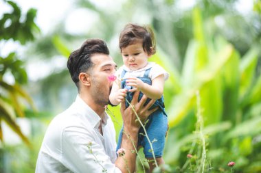 Aile bireyleri kavramı, baba ve bebek eğlencesi açık hava çimen bahçesinde oynamak, eğlenceli ve mutlu bir gülümseme, çocukluk ve ebeveyn sevgisi yazları evde.