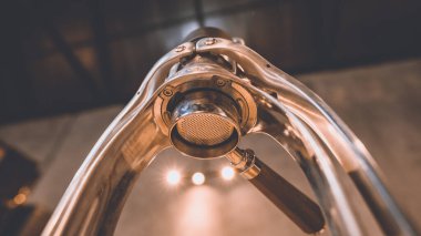 Profesyonel barista sıcak içecek espresso yapıyor. Eskimiş ahşap masa üzerinde kahve yapıyor. Kafede yavaş bir bar, sabahları cam bir fincana kafein hazırlıyor.