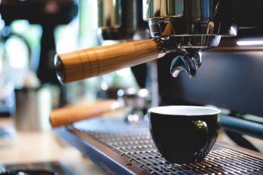 Kafede kahve fincanına espresso yapan profesyonel barista, kafein makinesi, sıcak suyu elle dolduran kişi, sabah kahvaltısı, sıcak içecekteki taze aroma.