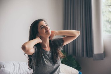 Genç, beyaz, uzun, kahverengi saçlı bir kadın. Sabahları yatakta uzanan, gülümseyen bir kız. Sabahları yatakta dalgalanan biri..