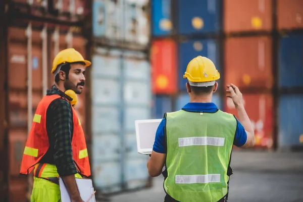 logistic worker teamwork and partner of foreman, engineer, and businessman working in an international shipping area, concept of business industrial and working in container yard to import and export