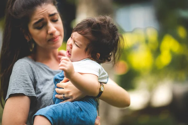 mother calms crying baby boy outside