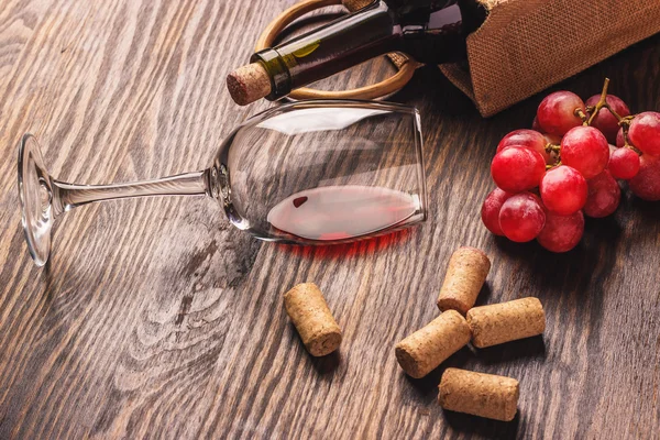 Glas mit Wein, Flasche und Trauben, Holzhintergrund — Stockfoto