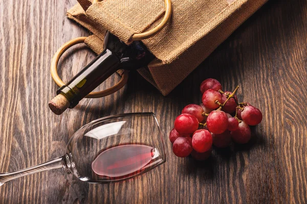 Cam şarap bir şişe ve üzüm, ahşap arka plan demet — Stok fotoğraf