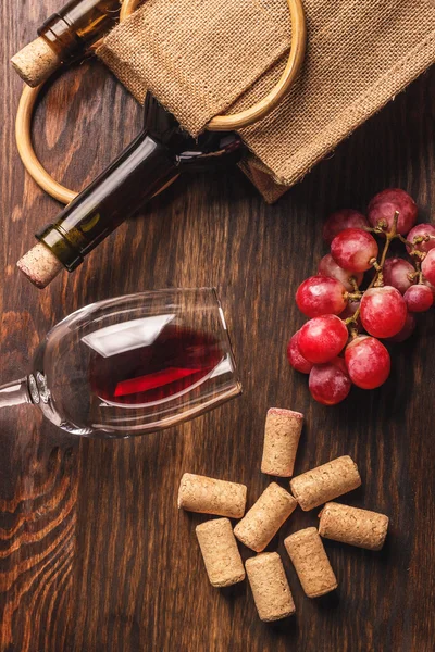 Glas med vin, flaska och massa druvor, trä bakgrund — Stockfoto