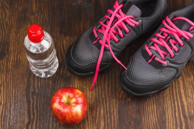 Spor ayakkabı, elma ve su şişe