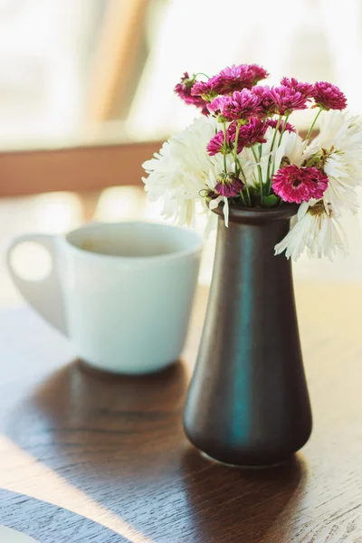 花とコーヒーのカップを持つ花瓶 — ストック写真