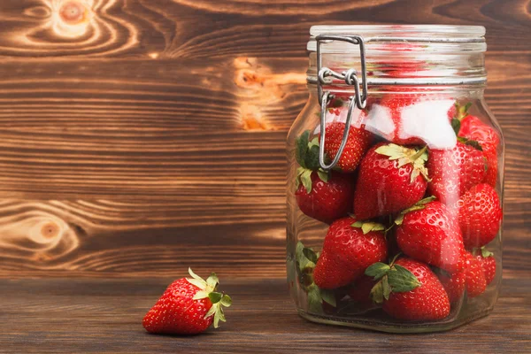 Fresas en el frasco sobre el fondo de madera — Foto de Stock