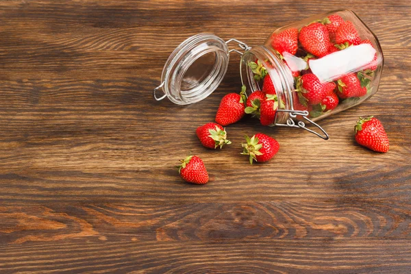 Fresas en el frasco sobre el fondo de madera — Foto de Stock