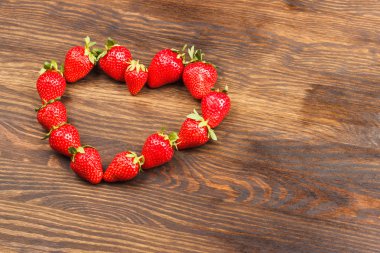 Ahşap arka plan üzerinde kırmızı çilek