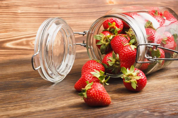 Fresas en el frasco sobre el fondo de madera — Foto de Stock