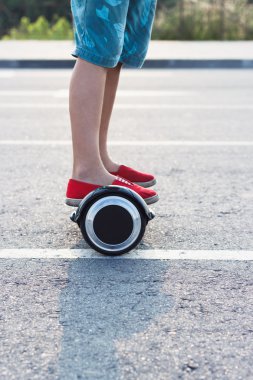 Oğlan siyah gyro scooter üzerinde açık havada duruyor