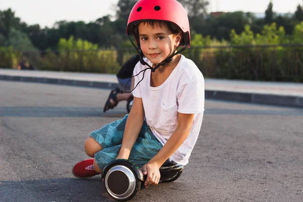 Çocuk açık havada siyah gyro scooter üzerinde oturur