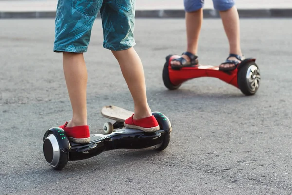 Jongens staat op de zwarte gyro scooter buitenshuis — Stockfoto